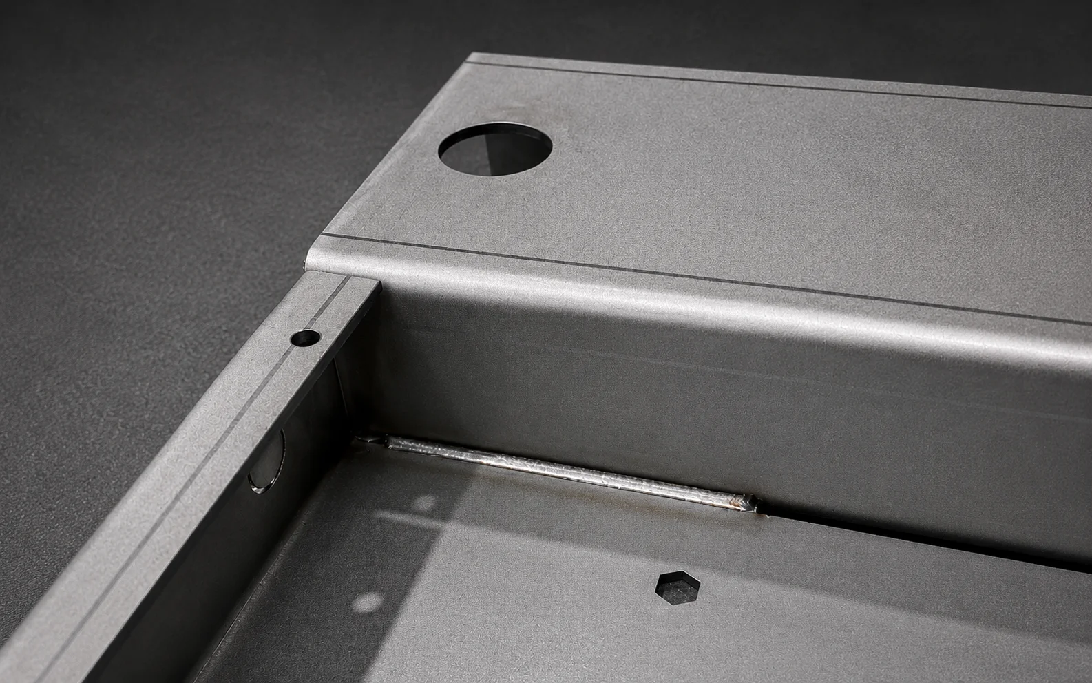 Welded carbon steel machine frame corner with laser-cut plates and mounting holes